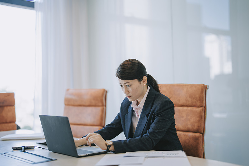 亚裔华裔女经理在会议室里用笔记本电脑专心工作,阅读电子邮件图片下载