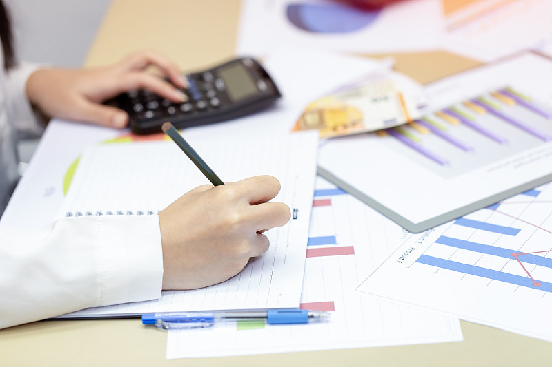 女商人在家查看利润文件,计算并记录数据成本图片下载